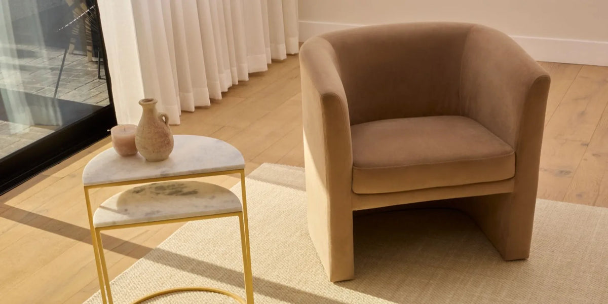 Neutral area rug for tile floors anchoring a calm living room with an upholstered chair
