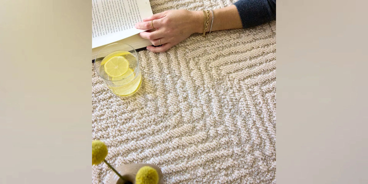 A thoughtfully furnished living room with a textured area rug beneath a seating group