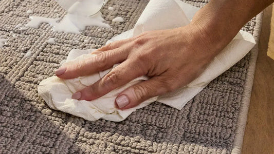 A family scene showing a spilled glass of milk on a neutral Elementa polypropylene area rug demonstrating its spill-resistant performance