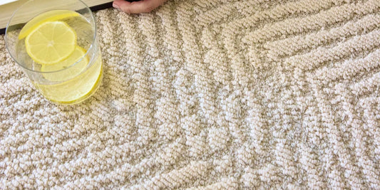 A thick performance polypropylene area rug in a bright family living room, with a spilled drink resting on the durable surface
