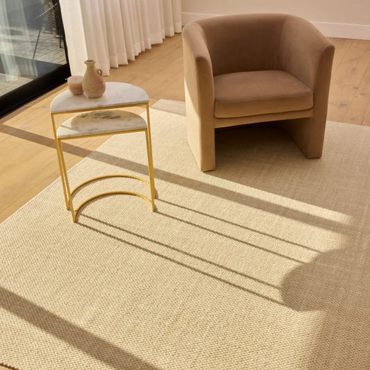 Neutral Groundstory area rug beneath an accent chair in a bright room